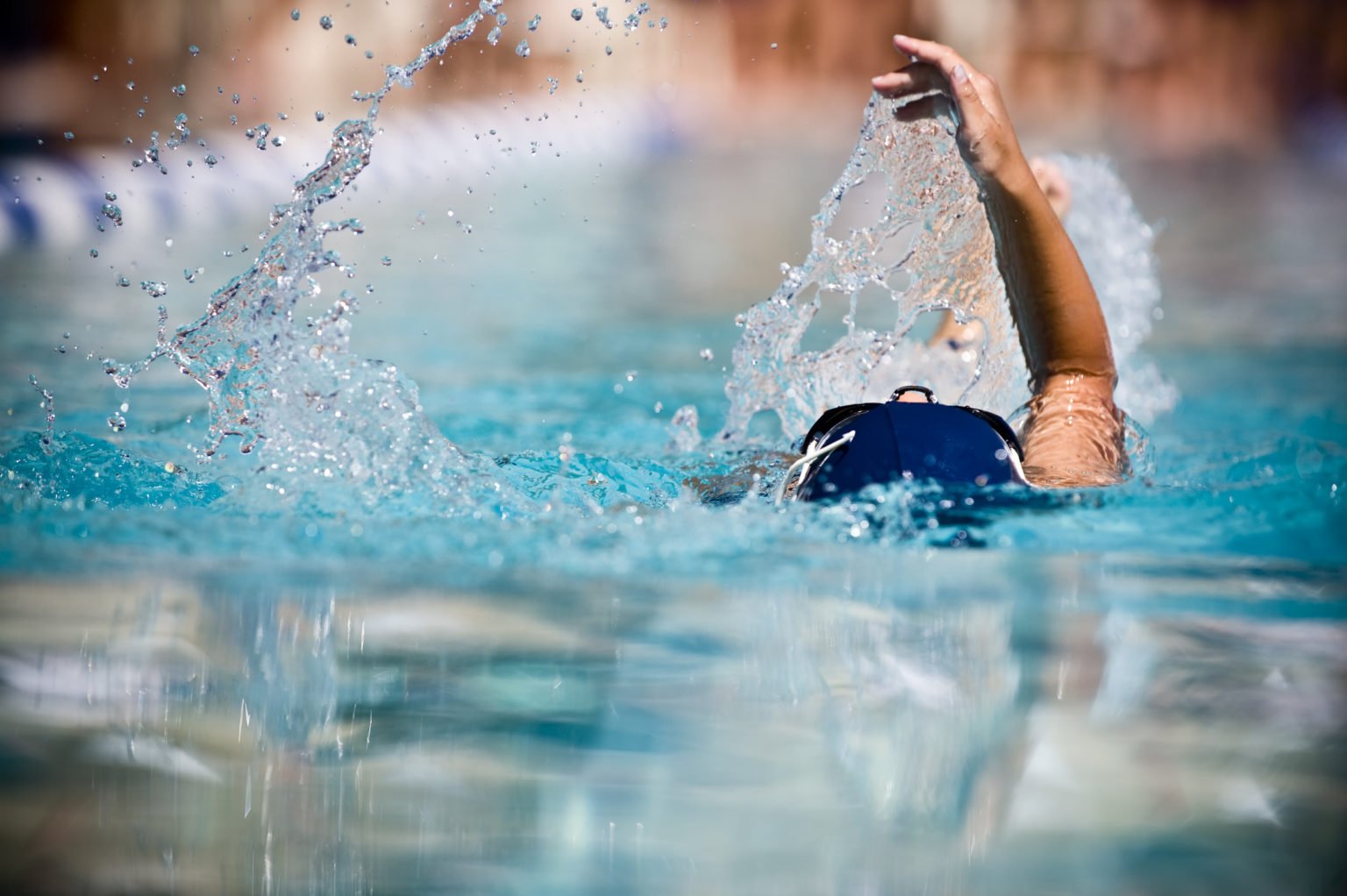 Female child swimming the backstroke at a swim meet.