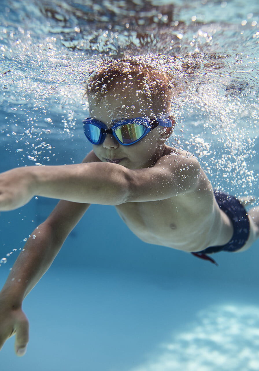 Portrait of little boy swimming underwater in the pool. Sunny summer day.
Nikon D850