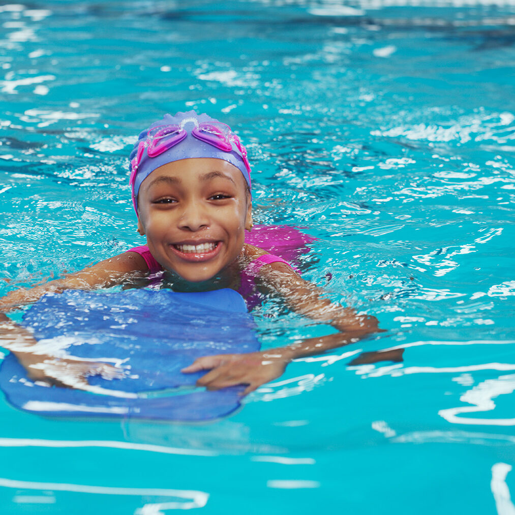 Portrait of an adorable young girl using a board during a swimming lesson