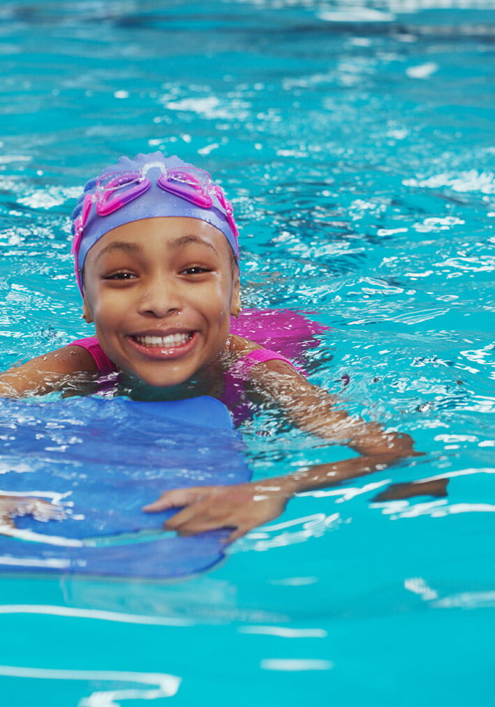 Portrait of an adorable young girl using a board during a swimming lesson